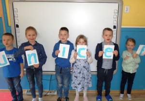 Dzieci pozują do zdjęcia z napisem unicef